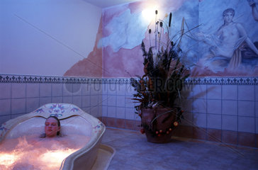 Frau relaxt in einem Orchideenbad