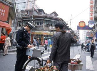 Polizeikontrolle eines Fussgaengers in Shanghai