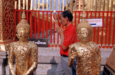 Betender in thailaendischem Tempel
