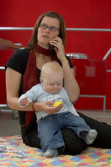 Berufstaetige Mutter mit Baby im Buero