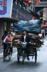 Schwerbeladener Radfahrer in Shanghais Centrum