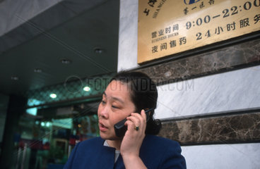 Frau mit Handy auf der Nanjing Lu in Shanghai