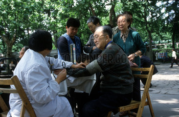 Rentner beim Blutdruckmessen im Fuxing Park in Shanghai