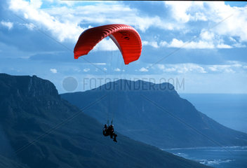 Kapstadt  Paraglider vor blauem Himmel in Suedafrika