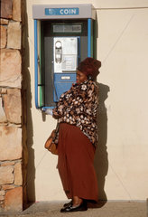 Cape Point  Schwarze Frau in Suedafrika am Telefon