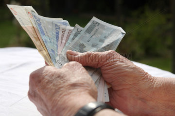 Berlin  Deutschland  eine Rentnerin haelt Geldscheine in der Hand