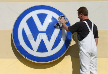 Schleswig  Arbeiter poliert Volkswagen-Symbol