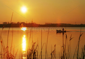 Eckernfoerde  Fischer auf einem See in der Abendsonne
