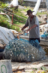 Ein Fischer sortiert sein Netz  Brasilien