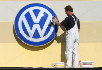Schleswig  Arbeiter poliert Volkswagen-Symbol