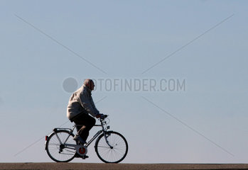 Westerhever  Radfahrer auf einem Deich an der Nordsee