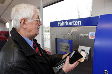 Fahrgast loest Fahrschein in AKN-Zug