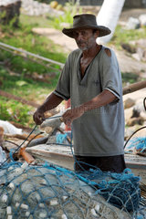 Ein Fischer sortiert sein Netz  Brasilien