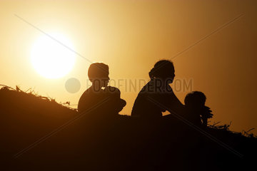 Familie sitzt auf einer Duene in Brasilien