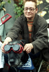 Berlin  eine Frau setzt ihrem Hund eine Fliegerbrille auf