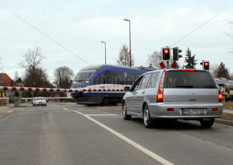 Neuenhagen  Deutschland  Autos warten an einem beschrankten Bahnuebergang