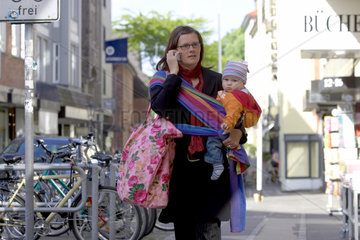 Berufstaetige Mutter mit Baby auf der Strasse