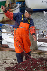 Fischer reinigt Netz auf Fehmarn