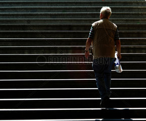 Berlin  ein aelterer Mann geht eine Treppe hoch