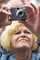 Aeltere Frau mit Digitalkamera