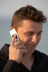 Kiel  junger Mann mit einem Handy am Ohr
