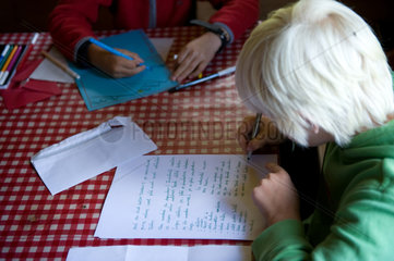 Blatti Alm  Schweiz  Jungen schreiben am Tisch einen Brief