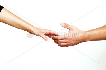 Mann und Frau reichen sich sehnsuechtig die Hand