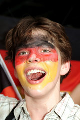 Berlin  Jugendlicher mit deutschen Nationalfarben im Gesicht