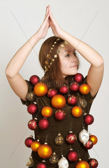junge Frau mit Weihnachtsschmuck behangen