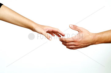 Mann und Frau reichen sich sehnsuechtig die Hand