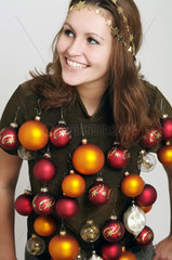 junge Frau mit Weihnachtsschmuck behangen