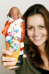 Frau haelt einen Schokoladenweihnachtsmann in der Hand