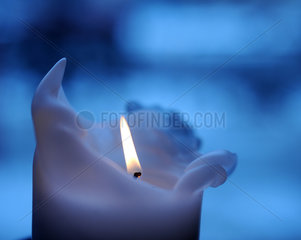 Berlin  Deutschland  brennende Kerze vor blauem Hintergrund