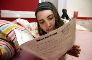 Junge Frau liest ihren Mietvertrag