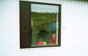 Varmahlid  Kind schaut aus dem Fenster