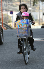 Kamakura  Japan  Frau faehrt mit ihrem Kind auf einem Fahrrad