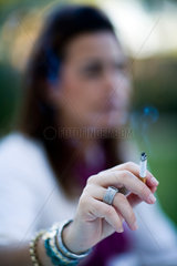 Sevilla  Spanien  junge Frau haelt eine Zigarette