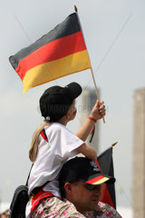 Berlin  Maedchen traegt eine Deutschlandfahne vor dem Olympiastadion