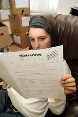 Junge Frau liest einen Mietvertrag