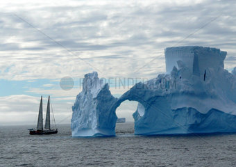 Eisberg mit Segelschiff