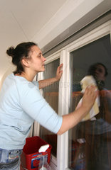 Gestresste Frau beim Fensterputzen