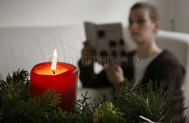 Eine Frau liest bei Kerzenlicht