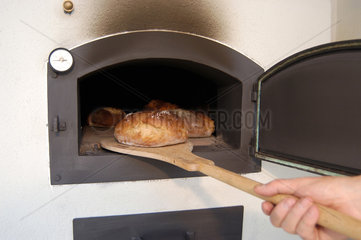 Brot wird aus dem Ofen geholt