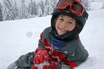 Niederau  ein Kind sitzt im Schnee
