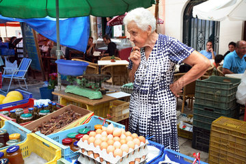 Santanyi  skeptisch schauende Frau auf einem Wochenmarkt