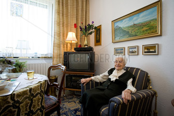 Mainz  eine aeltere Frau sitzt auf einem Sessel in ihrem Zimmer