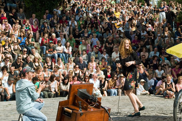 Berlin  Deutschland  ein Karaokesaengerin singt vor Publikum im Mauerpark