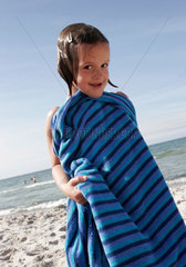 Neuhaus  ein Kind posiert im Badehandtuch am Ostseestrand