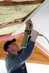 Handwerker beim Verkleiden der Dachschraegen