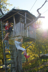 Kinder spielen an einem Baumhaus im Schwarzwald